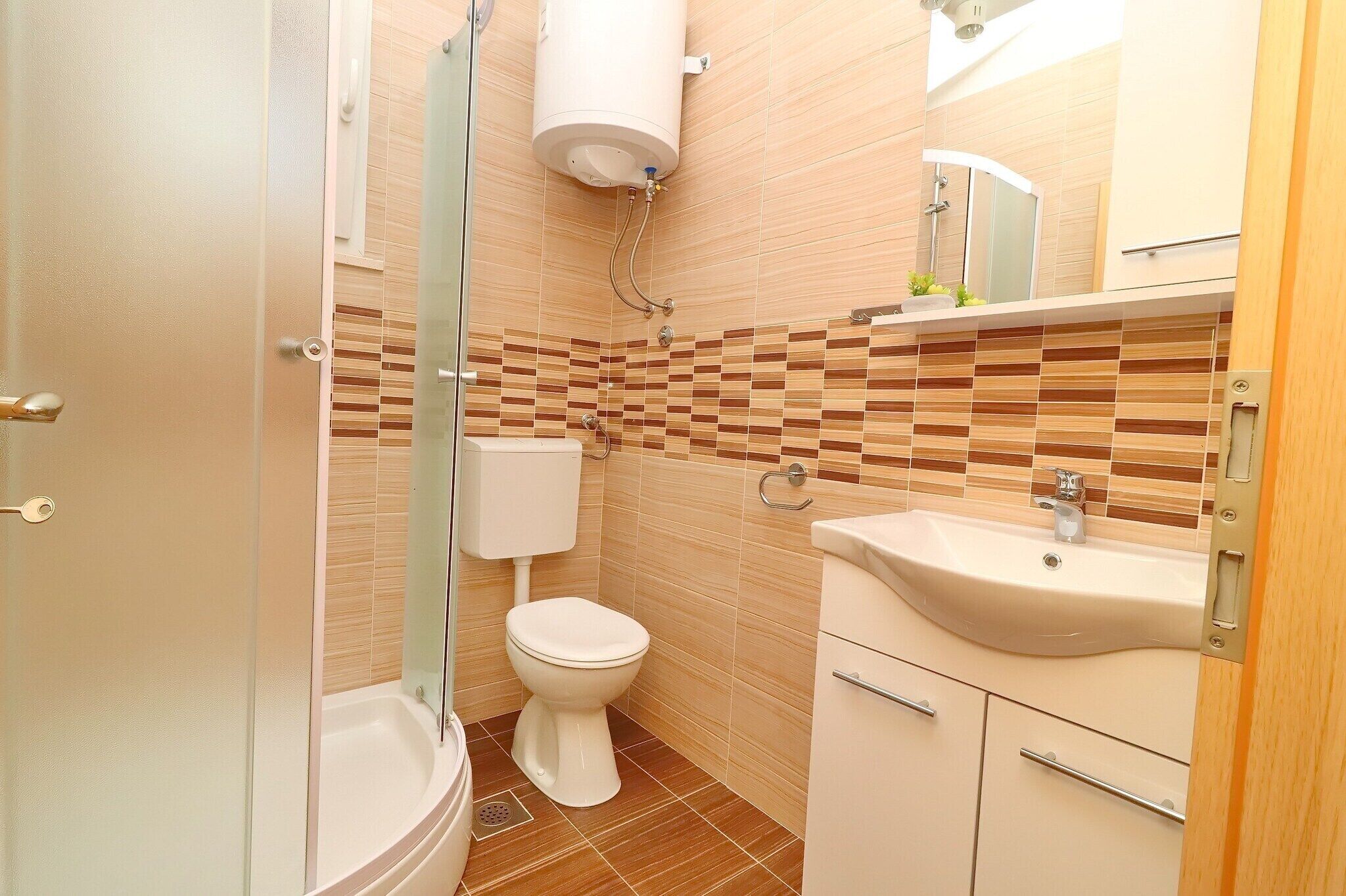 A bathroom with a toilet, sink, and shower.