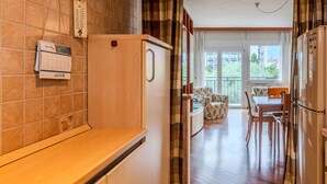 Une cuisine compacte dotée d’un plan de travail en bois, d’un réfrigérateur et d’un coin repas avec une table et des chaises.