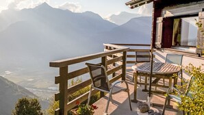 A wooden deck with a table and chairs overlooking a mountainous landscape. - Crettamour by Interhome (Veysonnaz)