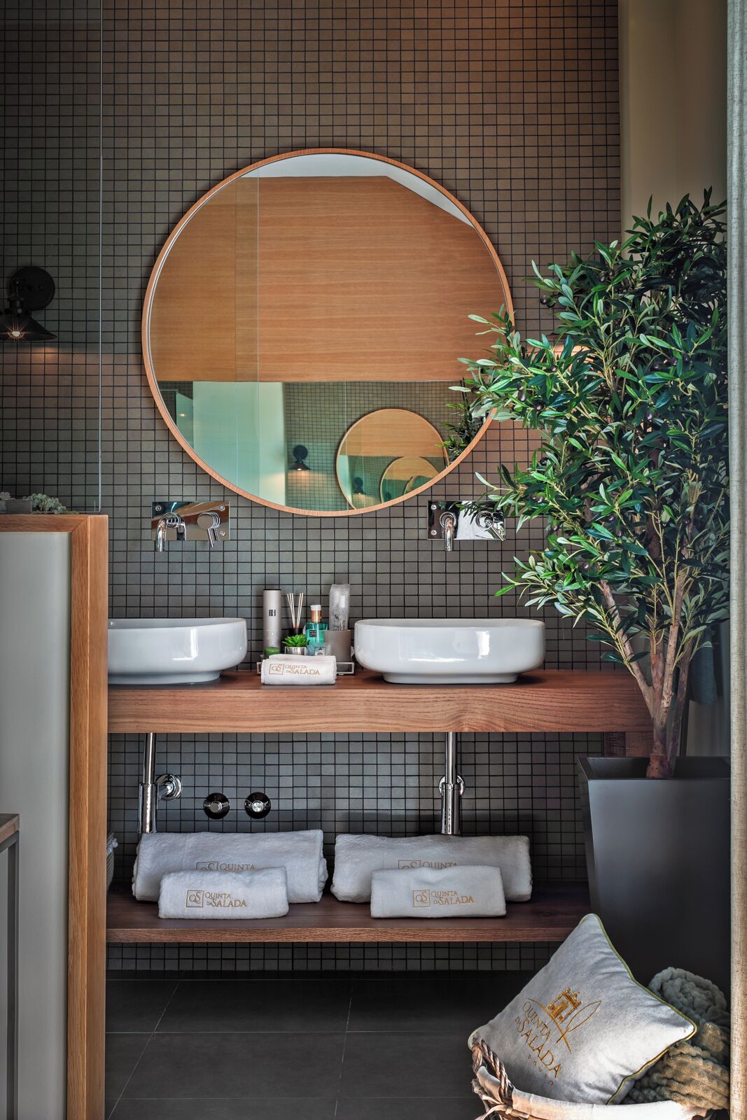 Un baño moderno con dos lavamanos, un espejo grande y una planta en maceta.