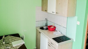 A compact kitchen with a sink, a red dish rack, and a stove. - Apartments Smokvica - One Bed/Apt with Balcony (Starigrad-Paklenica)