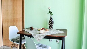 A dining table with a placemat, a vase with a rose, and a plate of food. - Apartments Smokvica - One Bed/Apt with Balcony (Starigrad-Paklenica)