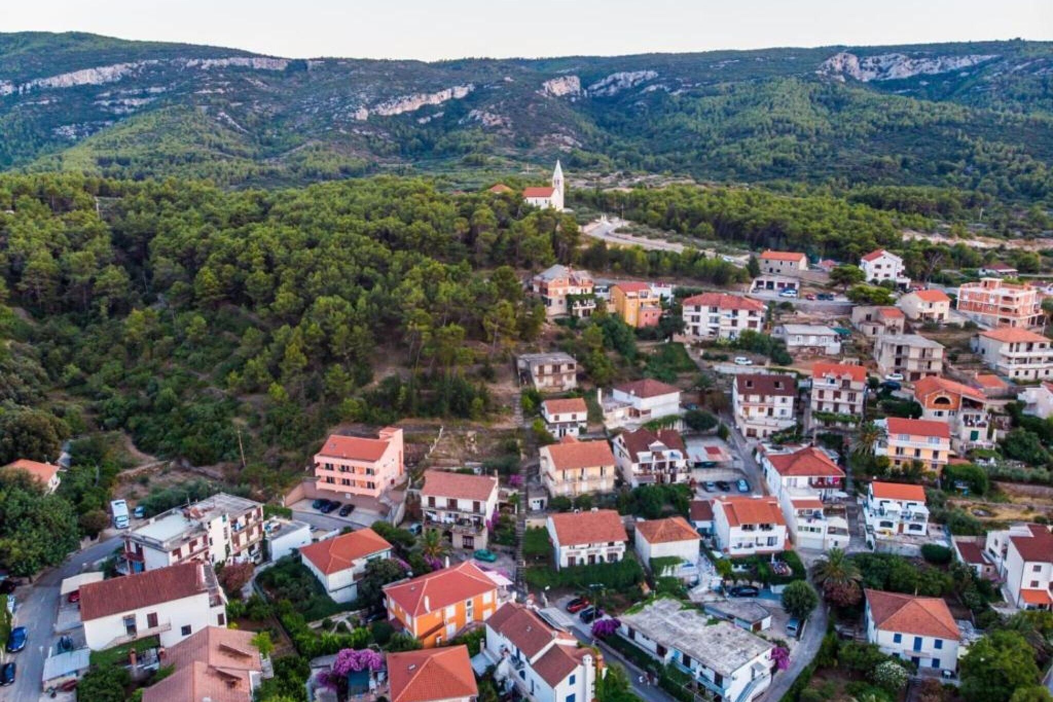 Zona residencial con casas, una iglesia y montañas al fondo.