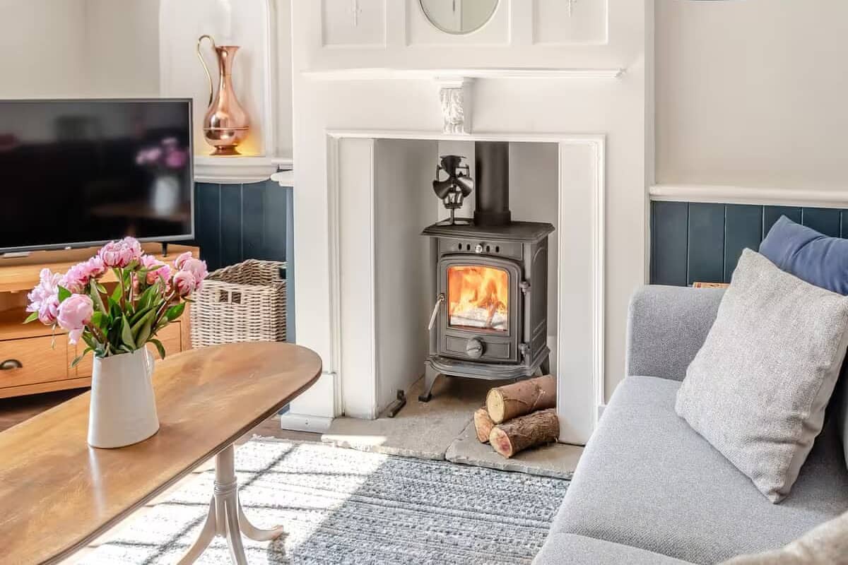 A cozy living room with a fireplace, a television, and a sofa.