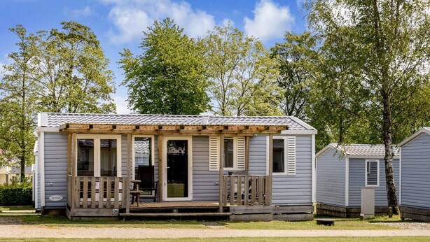 A small, single-story mobile home with a porch and a covered outdoor seating area. - 6 Person Holiday Park Home in Jelling (Jelling)