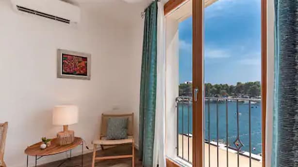 A room with a view of the sea, a wooden chair, a small table with a lamp, and a framed picture on the wall. - Mamma mia luxury rooms - Double Room with Sea View (Relaxing beachfront paradise) - 2 (Trogir)