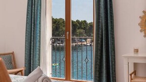 A room with a bed, a chair, a small table, and a window with a view of a marina. - Mamma mia luxury rooms - Double Room with Sea View (Relaxing beachfront paradise) - 2 (Trogir)