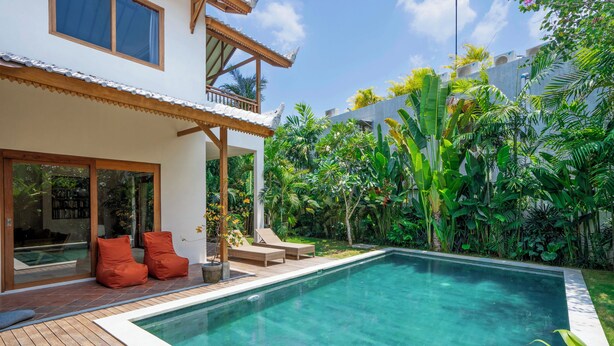 A modern house with a swimming pool, wooden deck, and outdoor seating area. - Yans Family Villa Canggu by Betterplace (Canggu)
