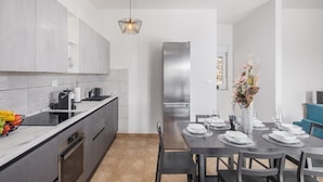 Une cuisine moderne avec un coin repas, des appareils en acier inoxydable et un vase décoratif.