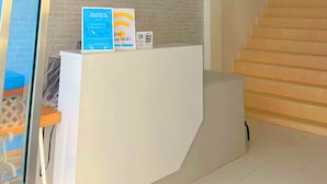 A reception desk with a signboard, a staircase, and a glass partition. - Whale Cha-Am (Cha-am)