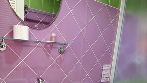 A bathroom with a white sink, toilet, and a glass shower enclosure. - Whale Cha-Am (Cha-am)