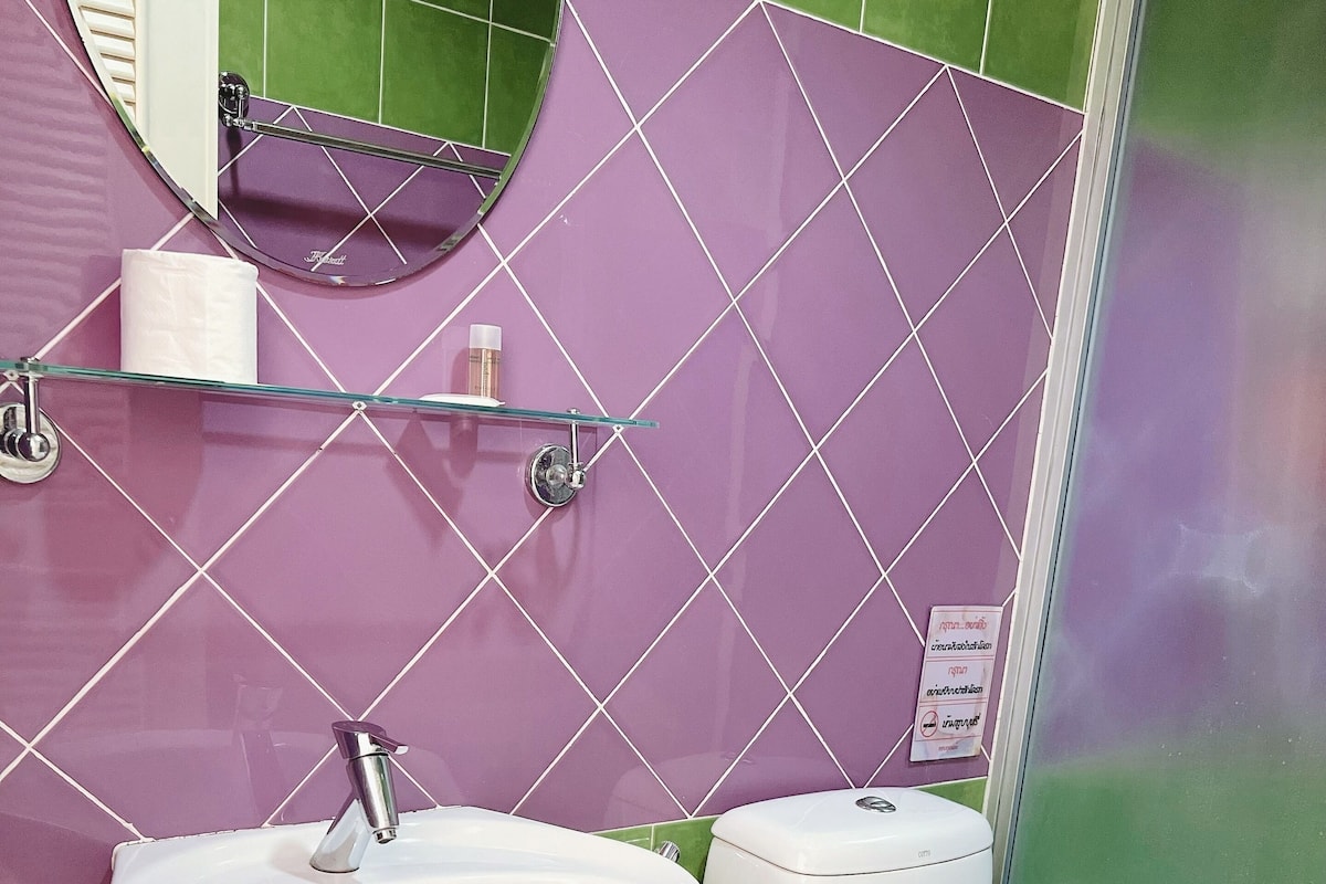Ein Badezimmer mit weißem Waschbecken, Toilette und einer Duschkabine aus Glas.