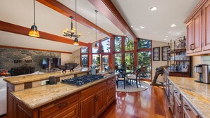Una cocina amplia con encimeras de granito, armarios de madera y una isla grande.