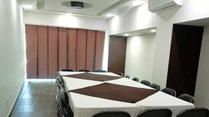 A conference room with a long table, chairs, and an air conditioning unit. - HOTEL PLAZA ELITE (Ciudad Valles)