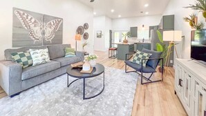 Ein modernes Wohnzimmer mit einem grauen Sofa, einem Couchtisch und einer TV-Konsole.
