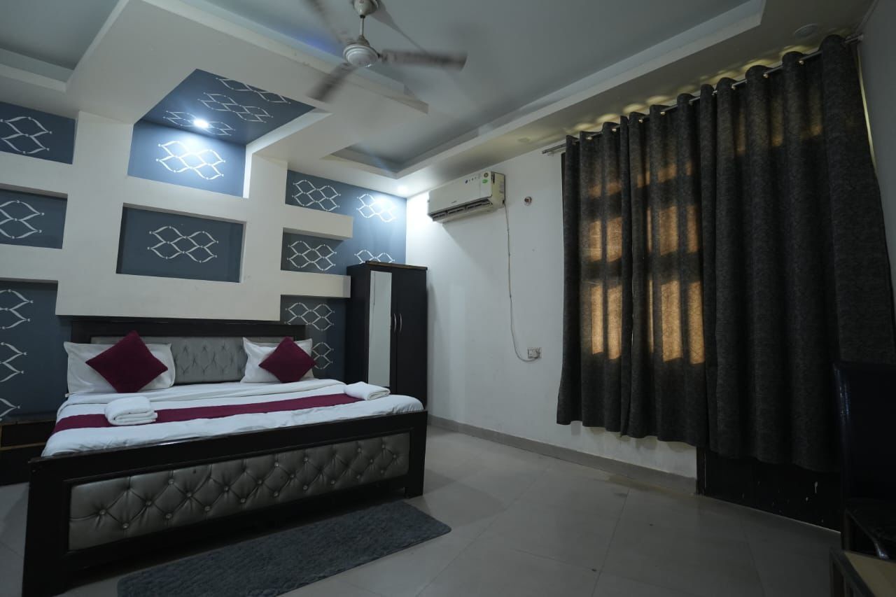 A bedroom with a bed, a ceiling fan, and a window with curtains.
