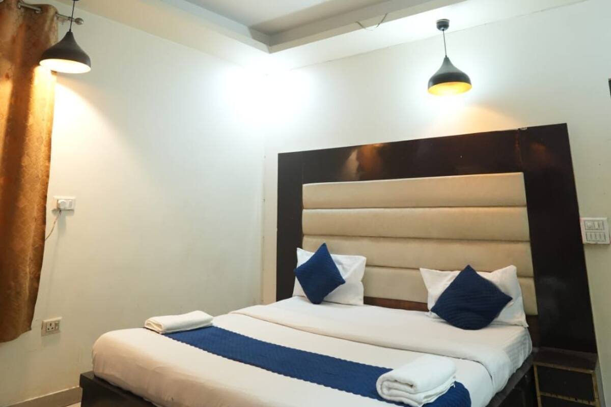 Un dormitorio moderno con cama, ventilador de techo e iluminación colgante.