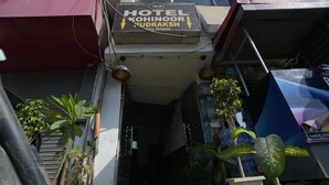 A hotel entrance with a sign reading "HOTEL KOHI NOOR RUDRAKSH Stay Happy". - Hotel Kohinoor (New Delhi)