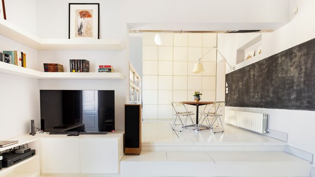 A modern living room with a flat-screen TV, a coffee table, and a dining area with chairs. - Charm and style in downtown Catania (Catania)