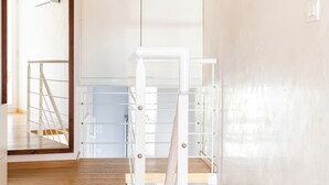 A modern interior with a wooden floor, white walls, and a staircase leading to a second floor. - Charm and style in downtown Catania (Catania)