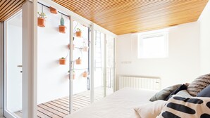 A bedroom with a bed, pillows, and a wooden ceiling. There are potted plants on a sliding door and a window with blinds. - Charm and style in downtown Catania (Catania)
