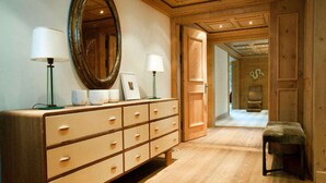 Een houten dressoir met meerdere lades, een grote spiegel en twee lampen.