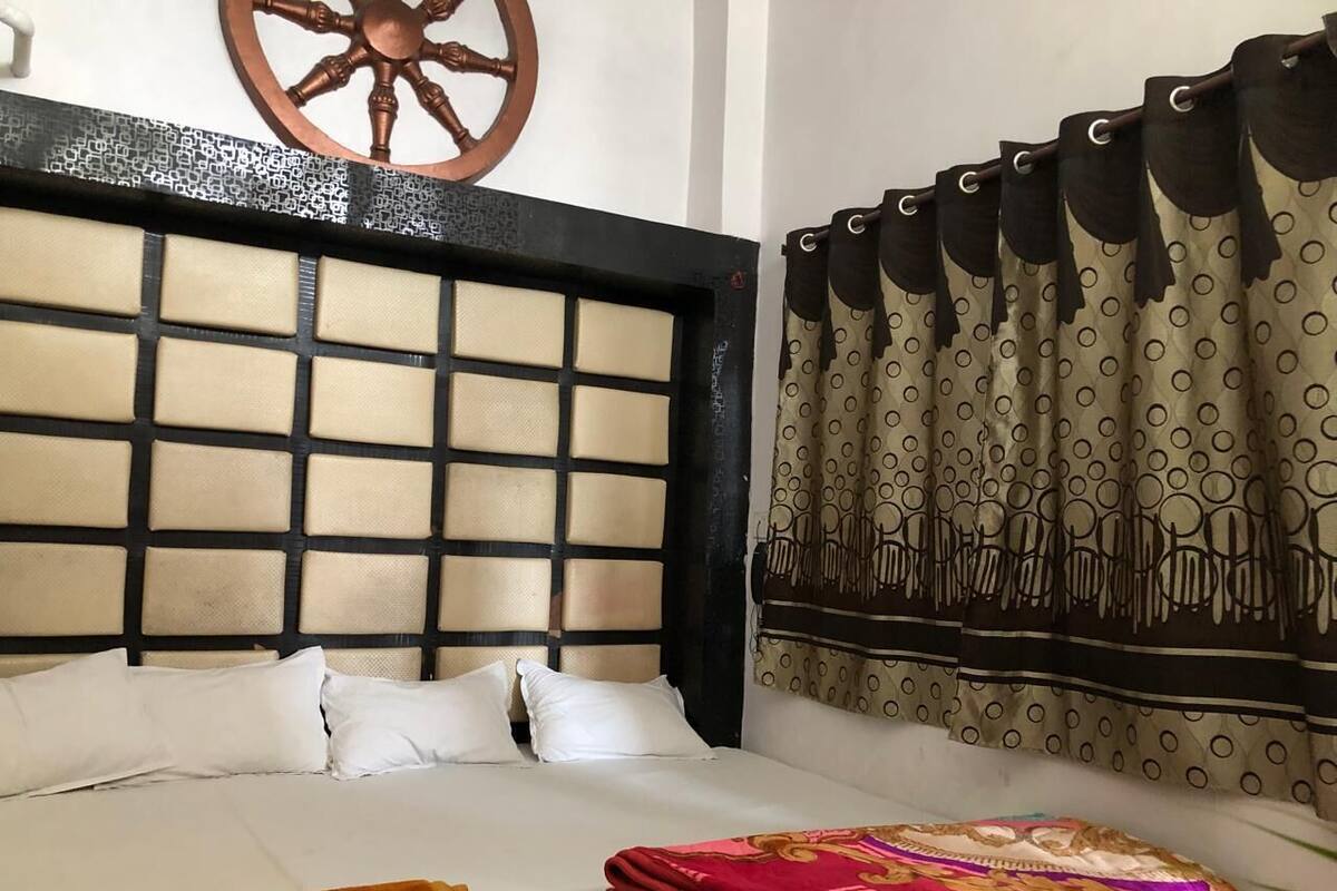 Ein Hotelzimmer mit einem großen Bett, einem Kopfteil mit Rautenmuster und einem Vorhang mit Punkten.