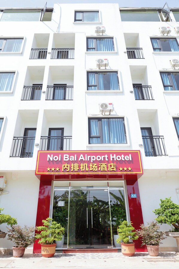 A hotel with a sign reading "Noi Bai Airport Hotel" and balconies with railings. - Noi Bai Airport Hotel (Hanoi)
