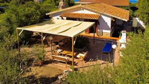 Une villa dotée d’un patio, de mobilier d’extérieur et offrant une vue sur la mer.
