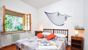 Une chambre à coucher avec un lit, une fenêtre, une décoration murale et des lampes de chevet.
