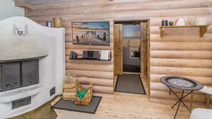 A cozy log cabin interior with a fireplace, a television, a kitchen, and a dining area. - Kiilopään tunturimajat b6 / kerttula by Interhome (Inari)