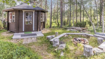 A cabin with a wooden exterior, a front door, and a small porch area.