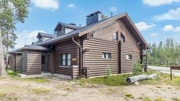 A log cabin with a sloped roof, a chimney, and a porch.