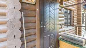 A log cabin with a wooden door marked "B6", a metal railing, and a stack of logs. - Kiilopään tunturimajat b6 / kerttula by Interhome (Inari)