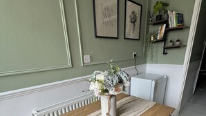 En matplats med ett träbord, en vas med blommor och inramade tavlor på väggen.