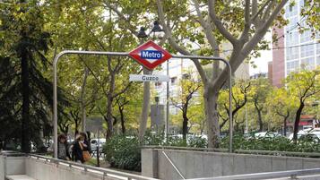 A metro station sign with a red diamond shape and the word "Metro" in white letters on a blue background. Below it, a white rectangular sign with "Cuzco" in black letters is visible.