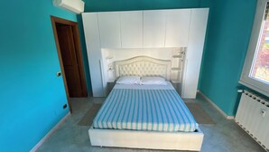 A bedroom with a bed, a wardrobe, and a window.