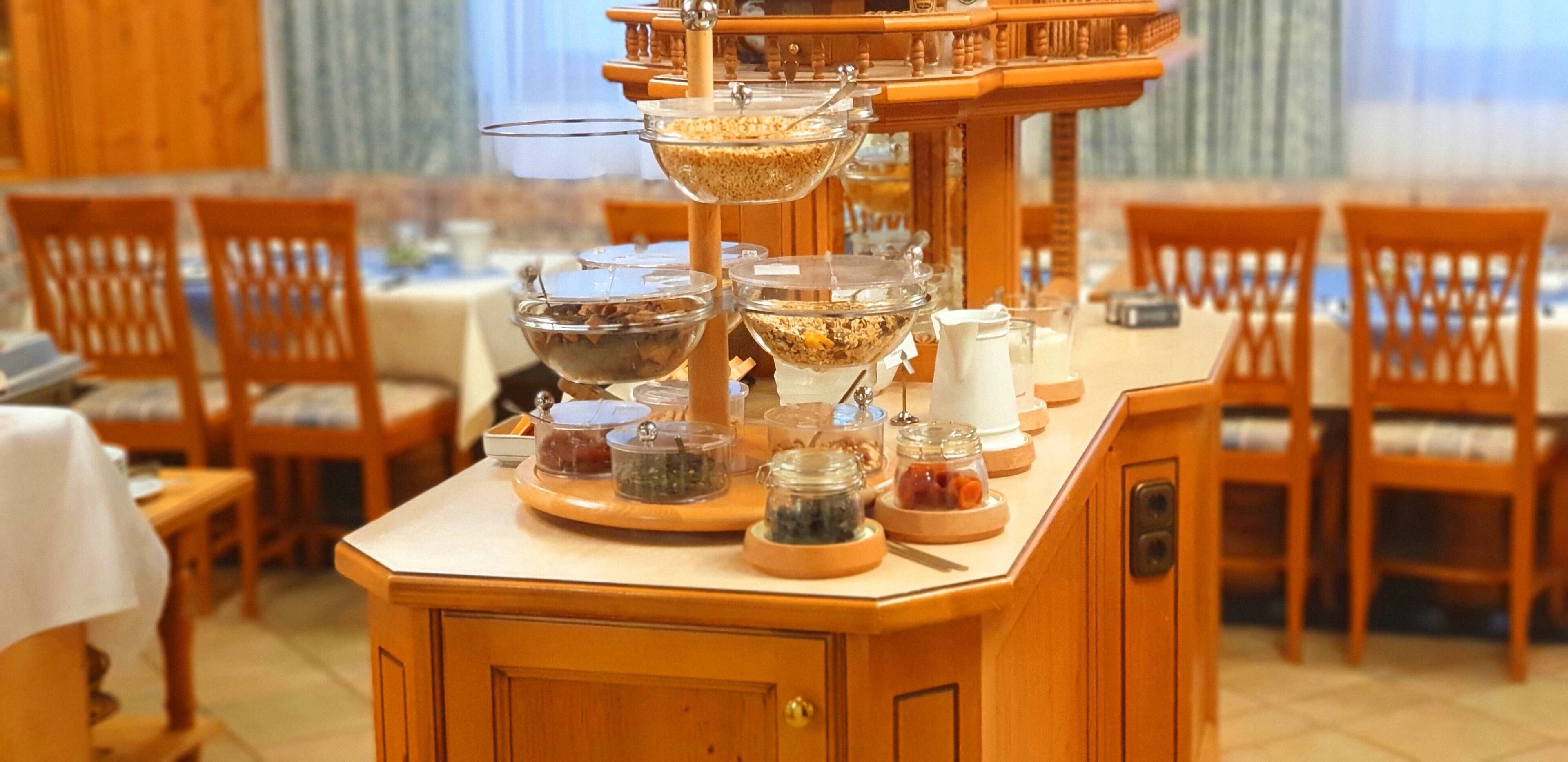 Una barra de buffet con diferentes recipientes de comida sobre un soporte de madera.