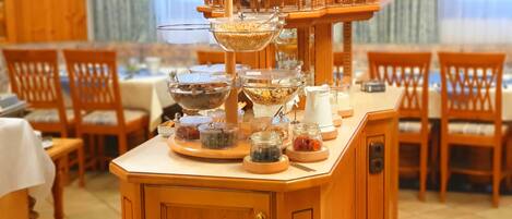 Una barra de buffet con diferentes recipientes de comida sobre un soporte de madera.