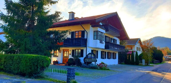 Un bâtiment à deux étages doté d’un balcon, d’une enseigne indiquant « Rosenhof » et d’une allée pavée.