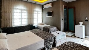 Une chambre d’hôtel moderne équipée d’un lit, de deux tables de chevet, d’un téléviseur et d’un appareil de climatisation.
