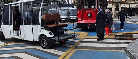 A tram at a crosswalk with people waiting.