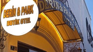 L’extérieur du Derin & Park Boutique Hotel se distingue par son entrée imposante et son enseigne décorative.