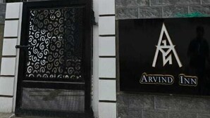 A modern building with a sign for Arvind Inn. - PPH Living Arvind Inn (Coimbatore)