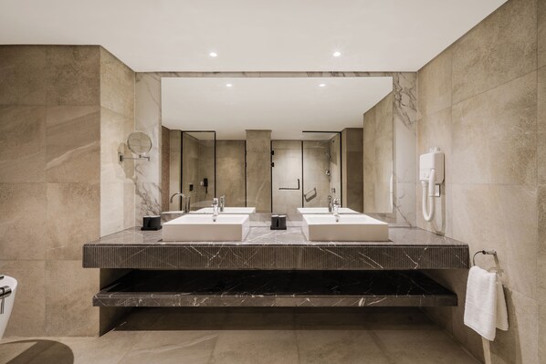 A modern bathroom with two sinks, a large mirror, and a towel rack. - The G Einbay Golf Resort (Ataqah)