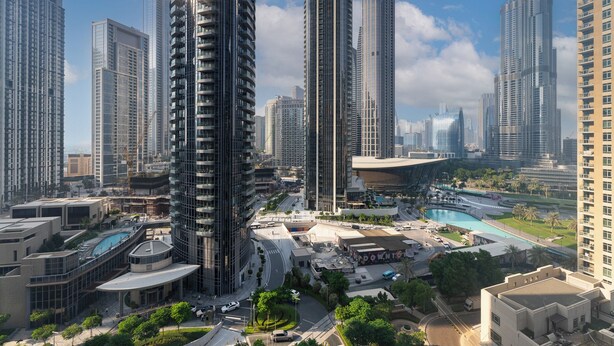 A high-rise urban area with modern architecture, including tall buildings and a curved structure with a pool.