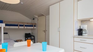 A compact room with bunk beds, a small table with chairs, and a kitchenette with a coffee maker. - 4 Person Holiday Park Home in Jelling (Jelling)
