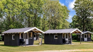 Three small cabins with wooden exteriors and metal roofs, each with a porch and a window. - 4 Person Holiday Park Home in Jelling (Jelling)