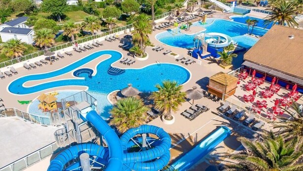 A large outdoor swimming pool with multiple slides and water features, surrounded by lounge chairs and umbrellas. - Mobile-home Camping Le Marisol - Torreilles-plage (Torreilles)