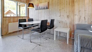 A wooden-paneled room with a dining table, chairs, a bench, and a bed. - 4 Person Holiday Park Home in Jelling (Jelling)